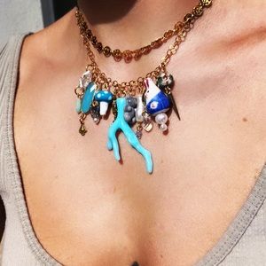 Gold steel necklace with mixed materials statement charms.